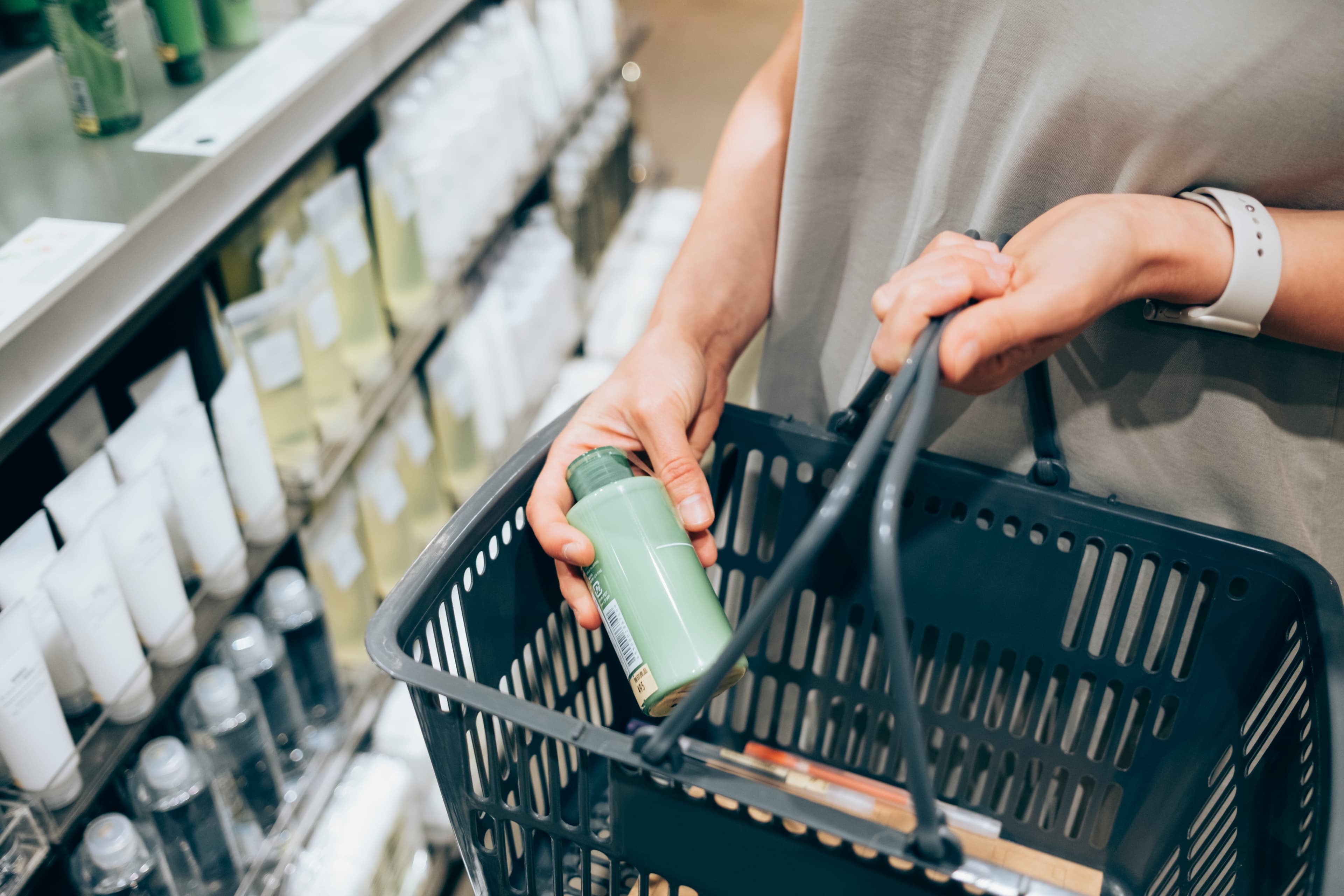 An anonymous female customer holding her basket while shopping on Black Friday.